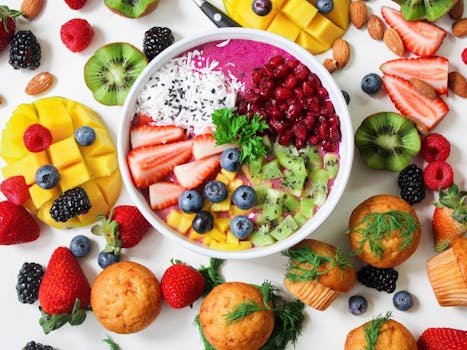 Vibrant smoothie bowl topped with assorted fresh fruits and muffins, perfect for a healthy snack.