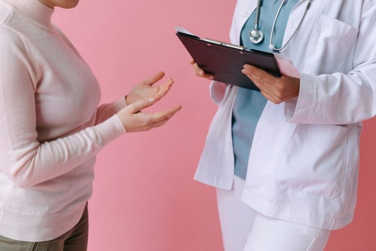 Close-up of a patient consulting a doctor with a clipboard in a medical setting.